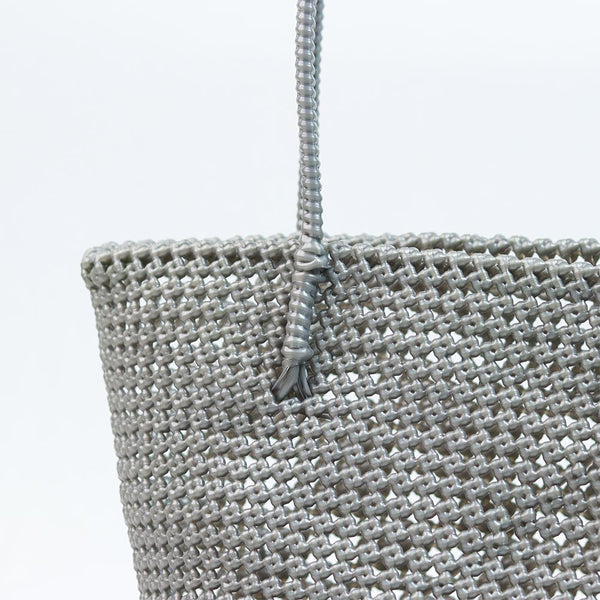 Woman carrying Kalapuri handwoven gray Koodai tote bag outdoors