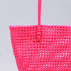 Woman carrying Kalapuri handwoven pink Koodai tote bag outdoors