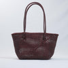 Kalapuri handmade maroon Koodai tote bag on wooden stool with dried flowers
