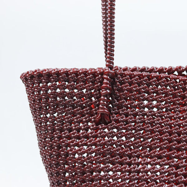 Woman carrying Kalapuri handwoven maroon Koodai tote bag outdoors