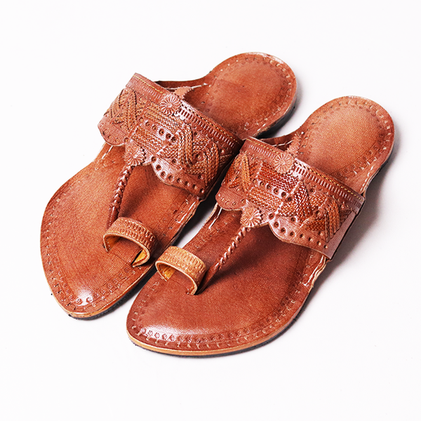 Pair of brown leather sandals with intricate designs on a white background