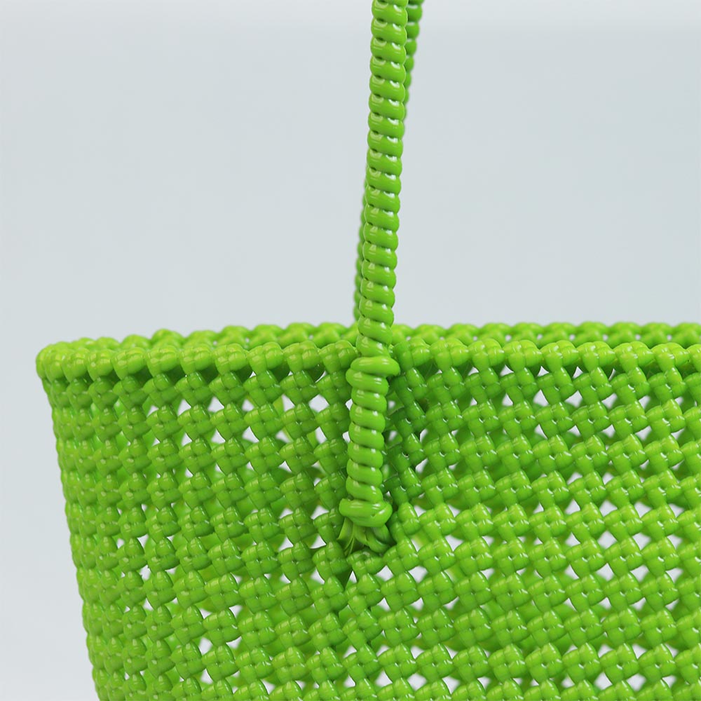 Woman carrying Kalapuri handwoven parrot green Koodai tote bag outdoors