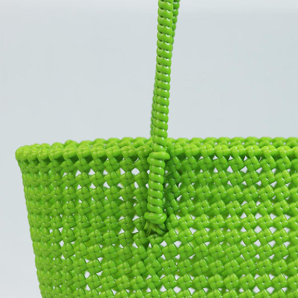 Woman carrying Kalapuri handwoven parrot green Koodai tote bag outdoors