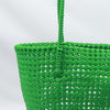 Woman carrying Kalapuri handwoven bright green Koodai tote bag outdoors