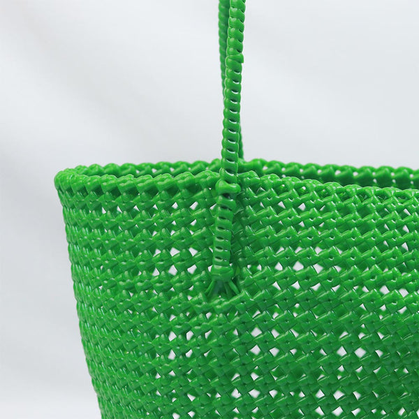 Woman carrying Kalapuri handwoven bright green Koodai tote bag outdoors