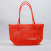 Kalapuri handmade orange Koodai tote bag on wooden stool with dried flowers