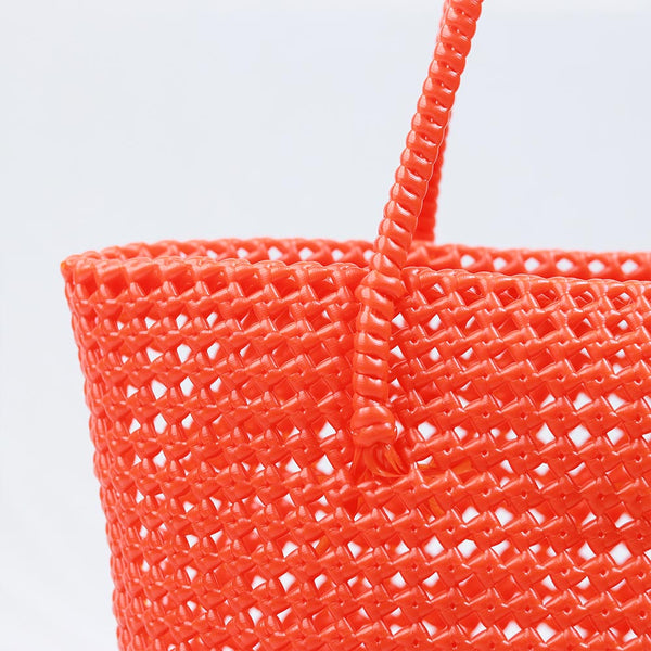 Woman carrying Kalapuri handwoven orange Koodai tote bag outdoors