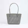Kalapuri handmade gray Koodai tote bag on wooden stool with dried flowers