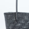 Woman carrying Kalapuri handwoven black Koodai tote bag outdoors