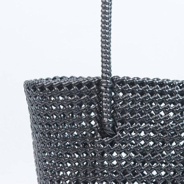 Woman carrying Kalapuri handwoven black Koodai tote bag outdoors