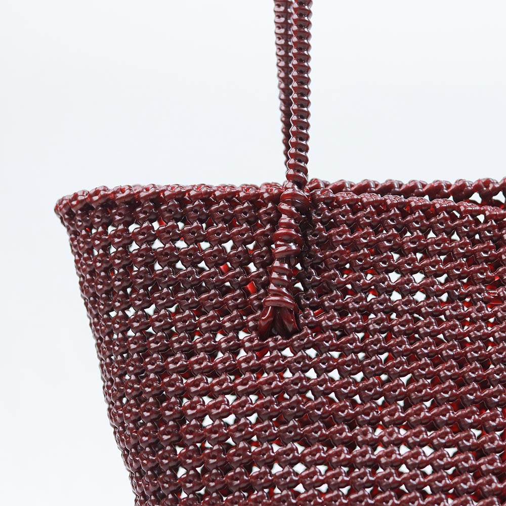 Woman carrying Kalapuri handwoven maroon Koodai tote bag outdoors