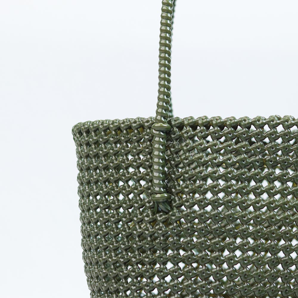 Woman carrying Kalapuri handwoven olive green Koodai tote bag outdoors