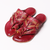 Pair of red sandals with gold accents on a white background