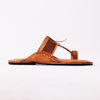 Brown sandal with woven design on a white background