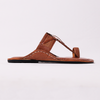 Brown sandal with a black sole on a light gray background
