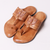 Pair of brown sandals with intricate designs on a white background