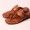 Pair of brown leather sandals on a light beige background