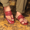 Red sandals worn on feet with a blurred background