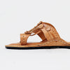 Brown sandal with decorative straps on a white background